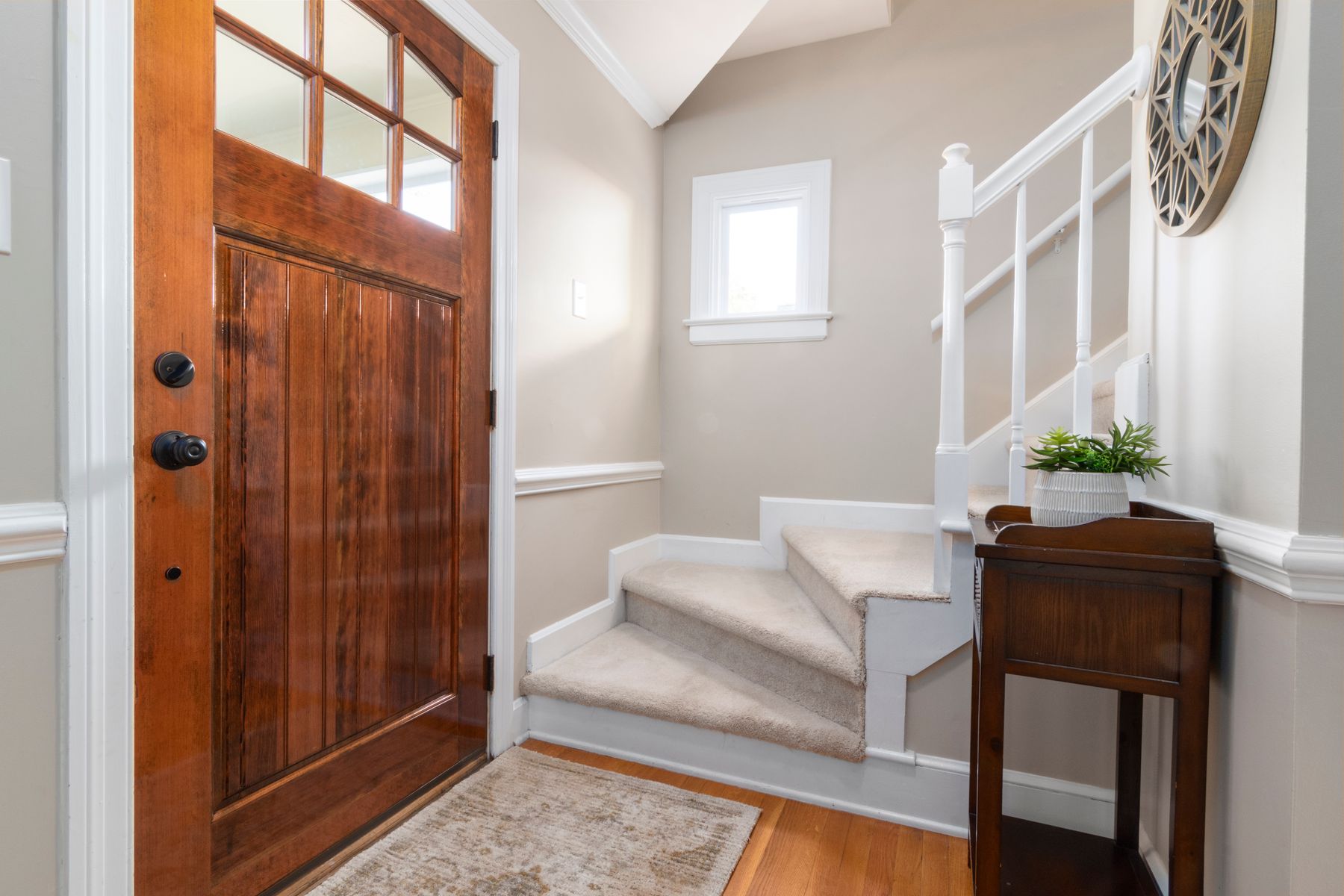 Warm finished entry beside a residential staircase